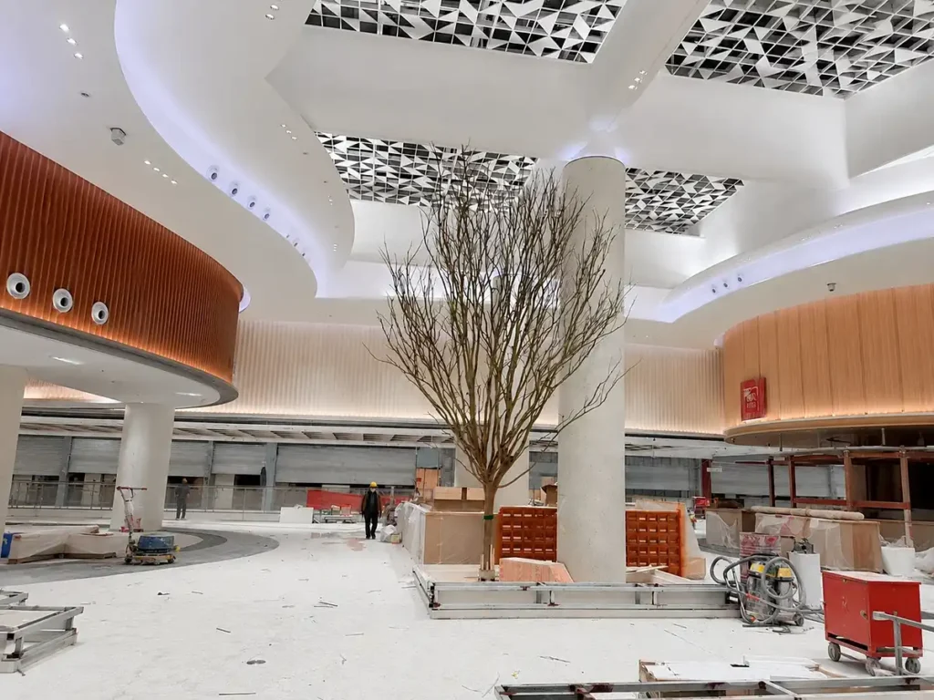 Artificial tree trunk installation before foliage assembly in commercial atrium